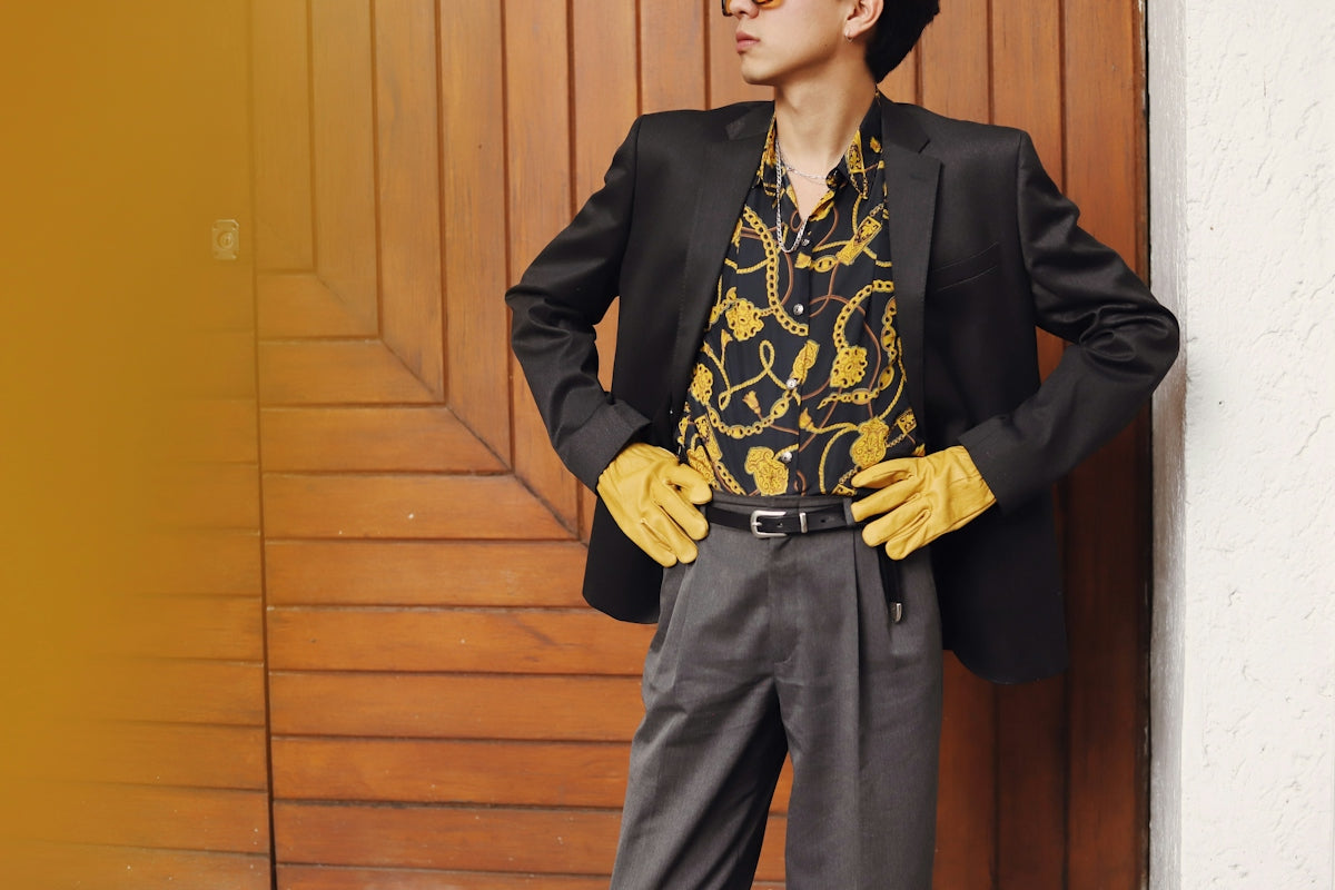 Man in stylish suit and gloves poses confidently