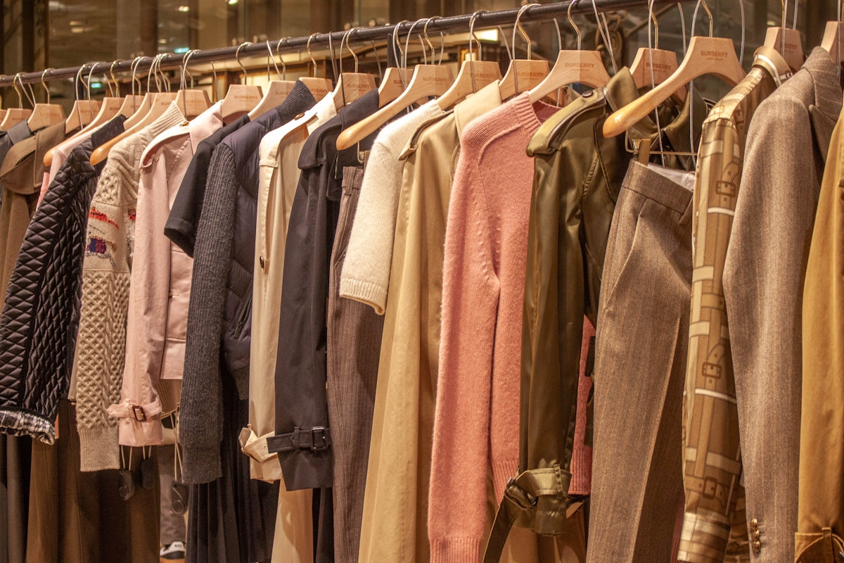 Assortment of clothing hanging on a rack.