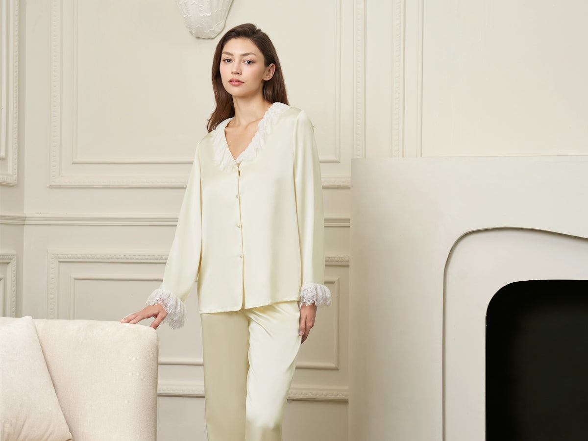 A woman in silk pajamas stands in a room
