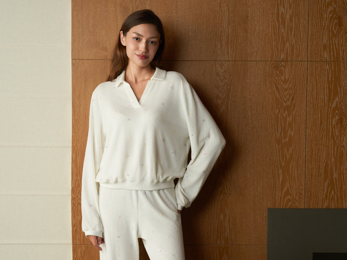 A woman wearing a white loungewear set indoors