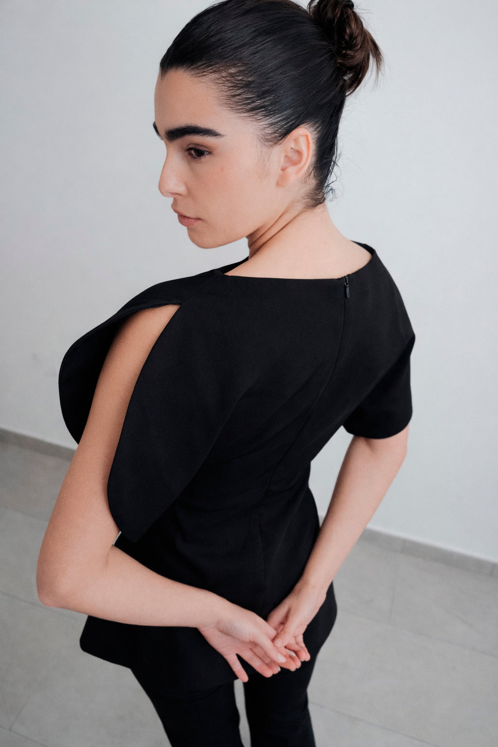 Blouse noire à manches fendues effet pétale vue dos sur modèle