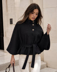 Cape noire en mouvement boutons asymétriques