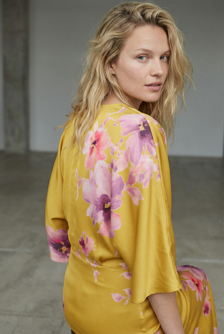 Vue rapprochée du dos d'une robe midi satinée imprimée fleurs roses sur fond jaune