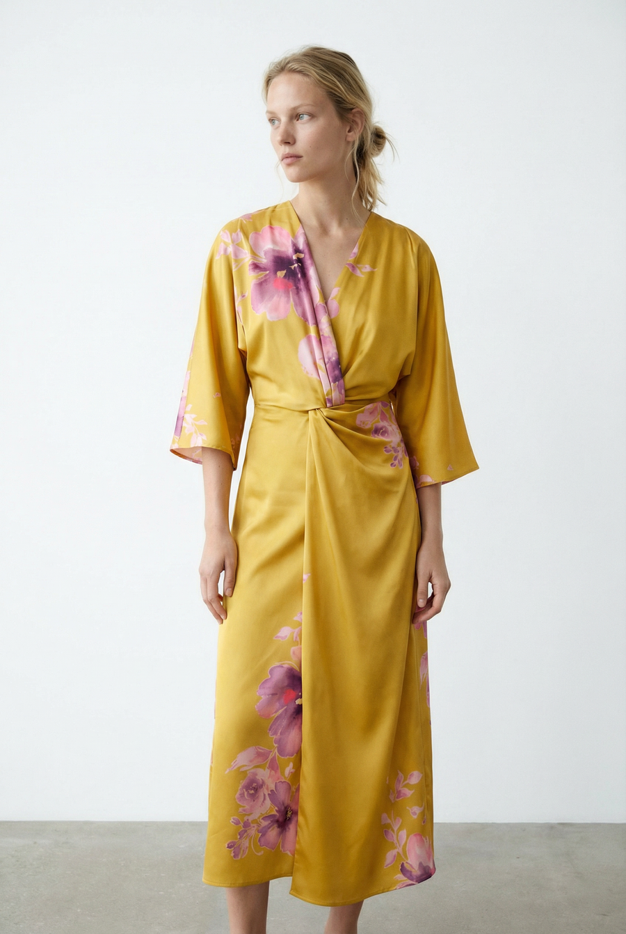 Robe satinée jaune imprimée de fleurs roses, col V et manches larges, vue de trois-quarts
