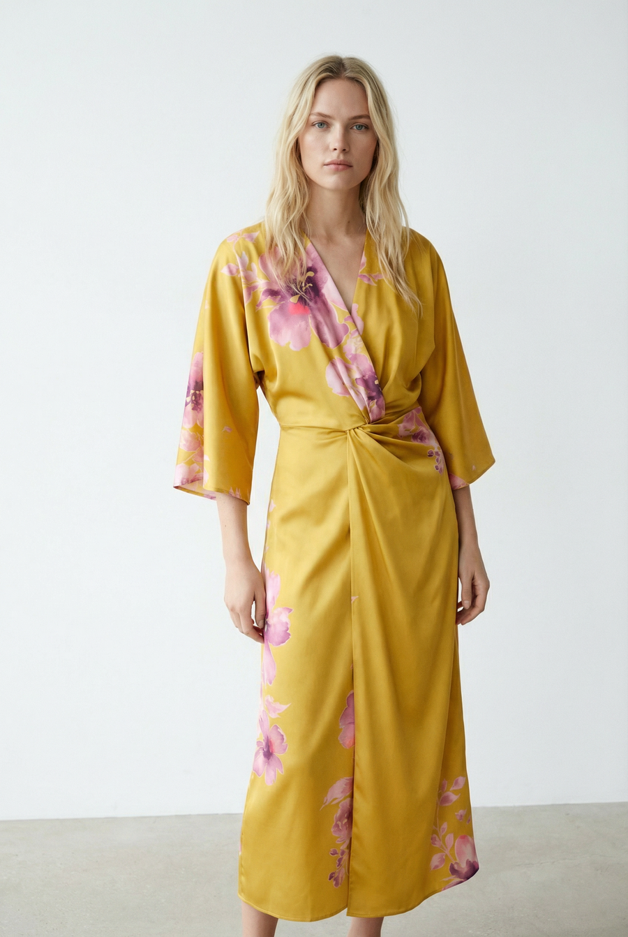 Robe midi croisée satinée jaune à fleurs roses, col V et manches larges, vue de face en lumière naturelle