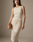 Femme stylée avec un haut côtelé et une jupe en dentelle crème en coton taille haute élégante, idéale pour un look estival.