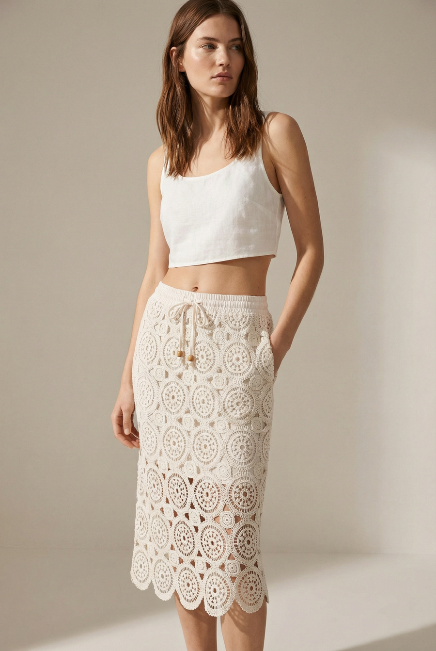Femme portant une jupe en dentelle crème en coton taille haute élégante avec un haut en lin, parfait pour un look décontracté et chic.