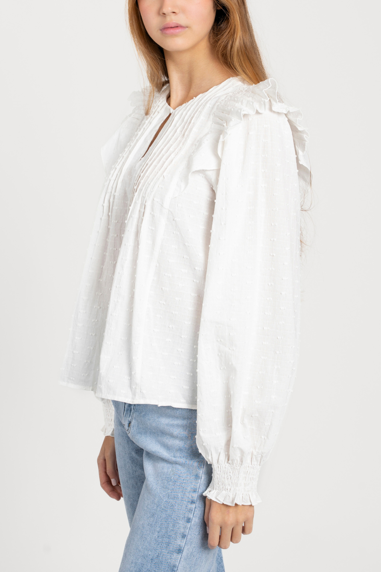 Profil d’un modèle en blouse plumetis coton blanc femme, présentant les manches et le style chic, blouse femme coton.