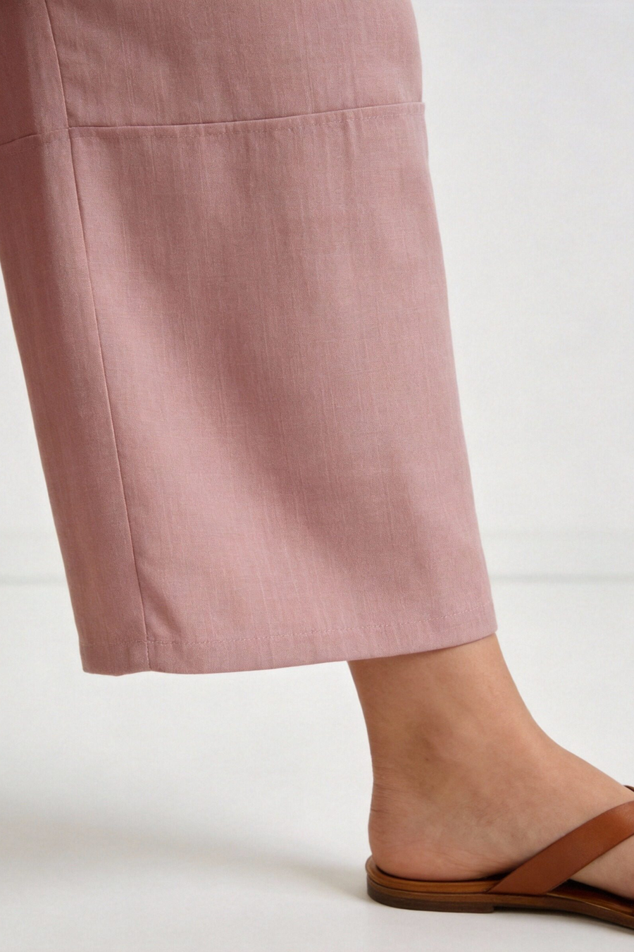 Pantalon court plissé taille haute ceinture élastique à poches rose, présenté à plat, montrant le design élégant et les finitions impeccables. Pantalon plissé femme.