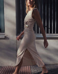 Robe midi beige chic, avec sa coupe stylée, photographiée en pleine marche pour un look moderne.