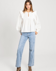 Blouse plumetis coton blanc femme avec manches longues, portée par un modèle, style chic et décontracté, blouse femme coton.
