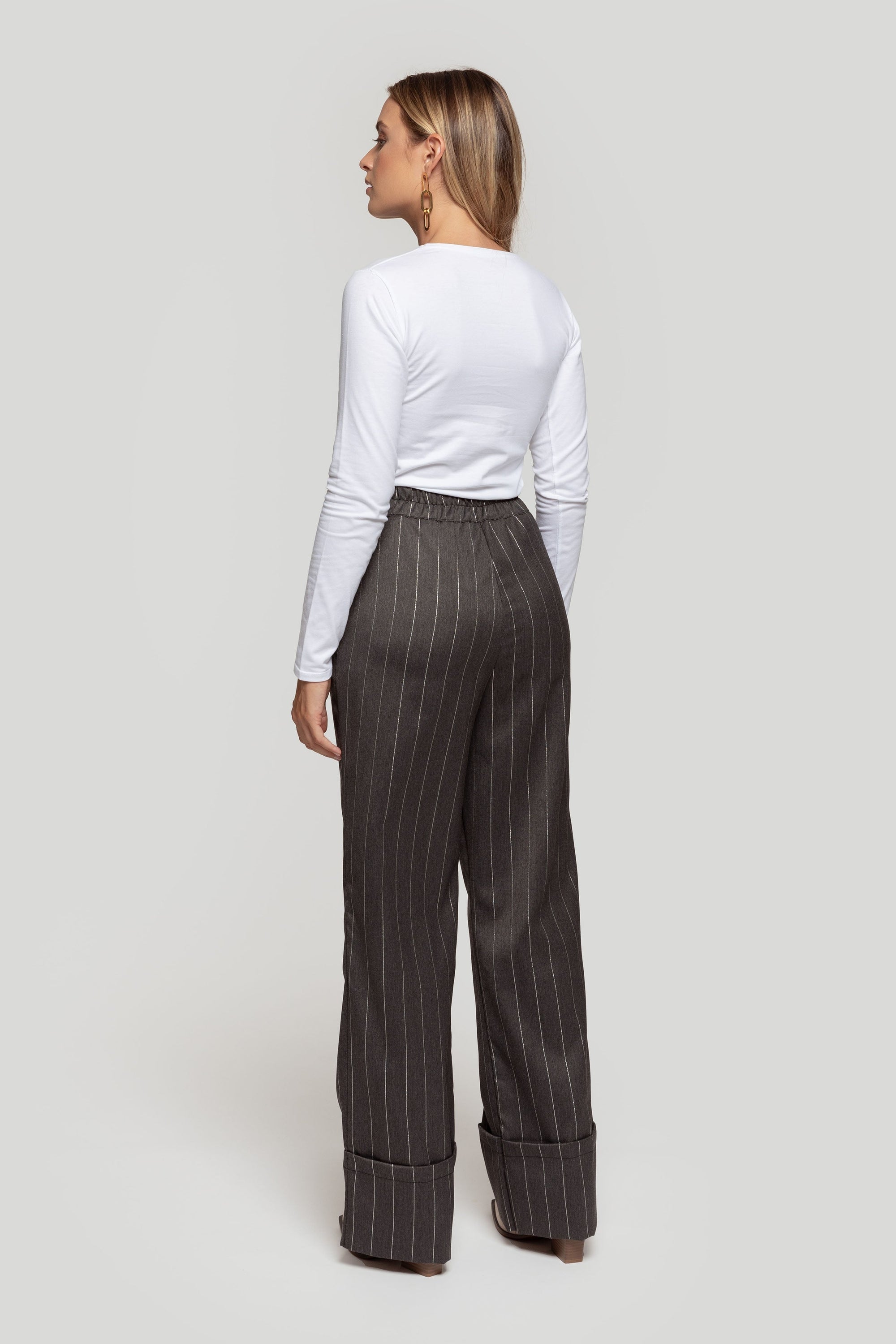 Zoom sur les poches et la fermeture du pantalon large rayé gris brillant, conçu comme un pantalon ample femme pratique et chic.