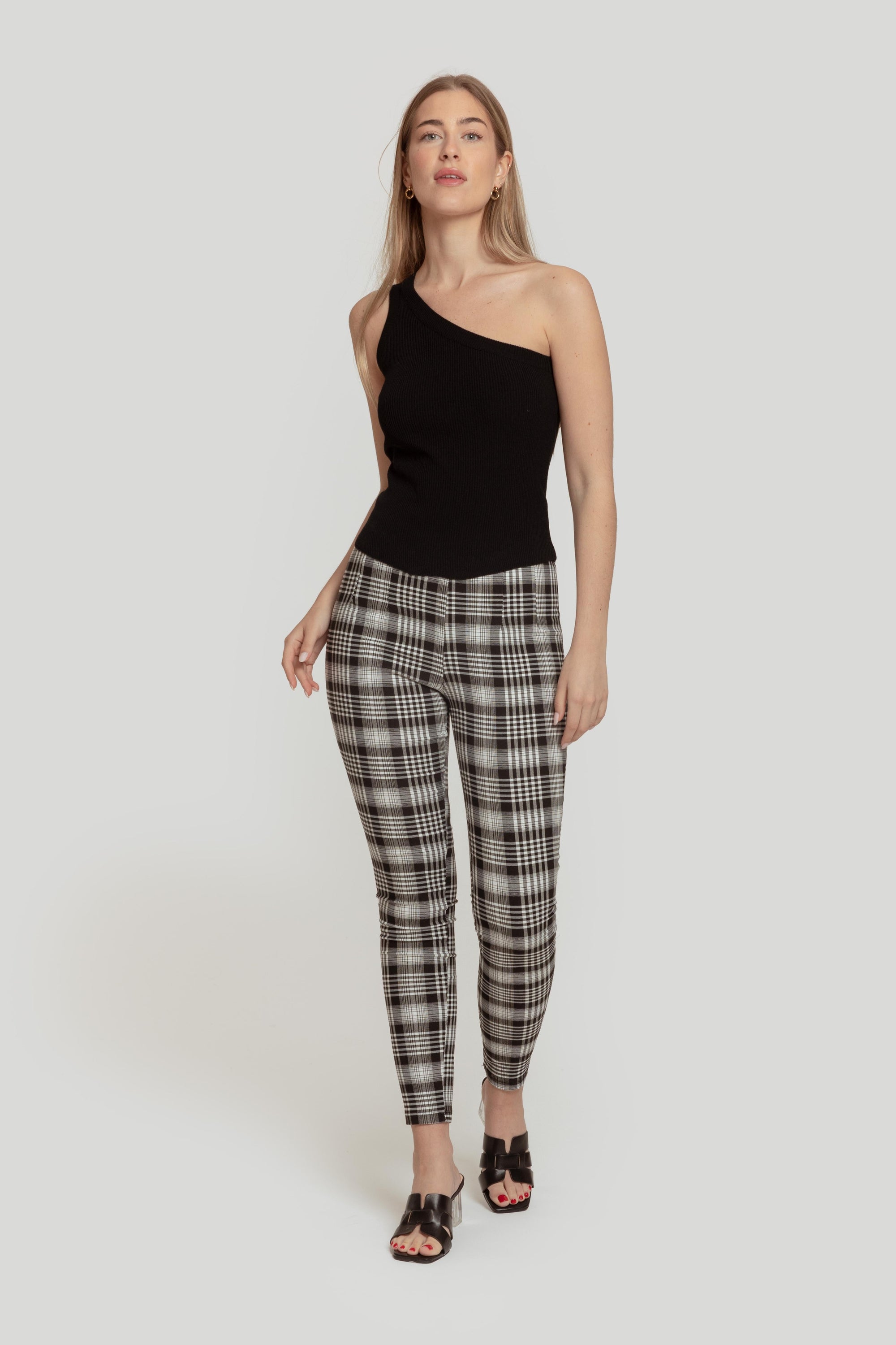 Femme en pantalon slim imprimé femme noir à taille élastique, marchant élégamment tout en affichant une posture confiante.