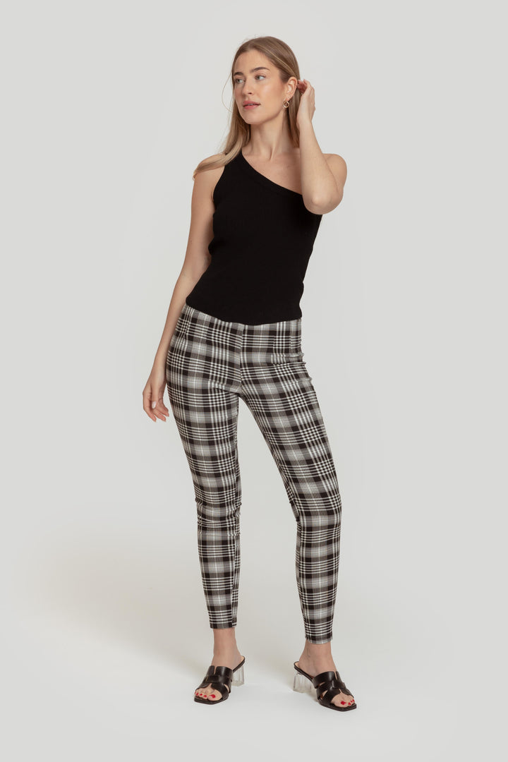 Modèle portant un pantalon slim imprimé femme noir à taille élastique, associée à un top à une épaule, pour un look moderne et élégant.
