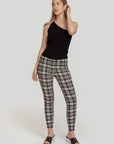 Modèle portant un pantalon slim imprimé femme noir à taille élastique, associée à un top à une épaule, pour un look moderne et élégant.