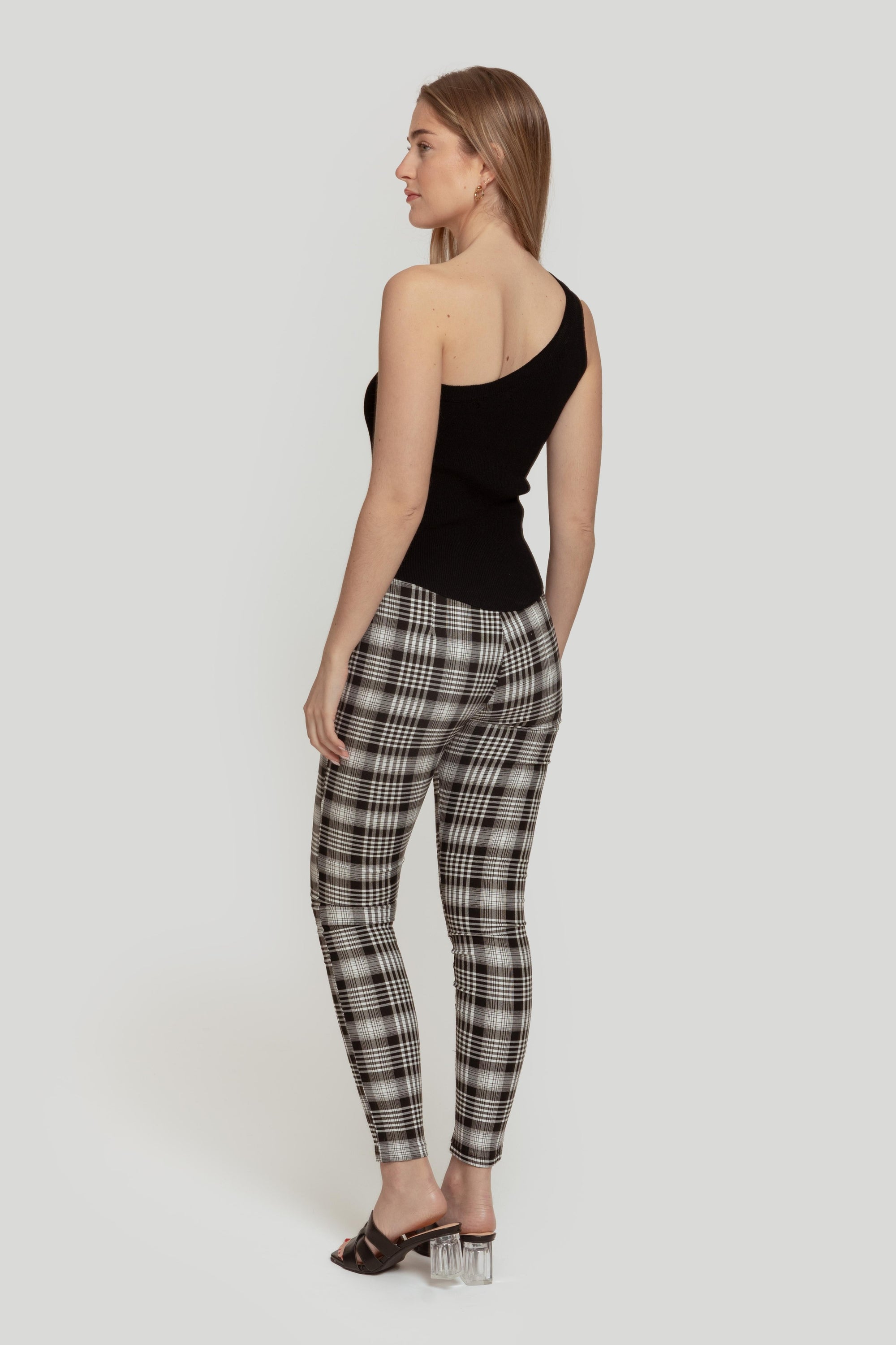 Vue arrière d'une femme dans un pantalon slim imprimé femme noir à taille élastique, mettant en valeur le style ajusté et contemporain.