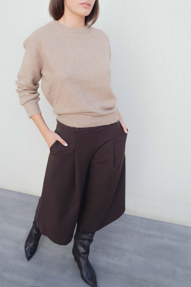 Bermuda long à pinces coupe droite marron coton stretch porté avec un pull beige, mettant en avant un look élégant et décontracté parfait pour les bermuda large femme ou bermuda femme long.