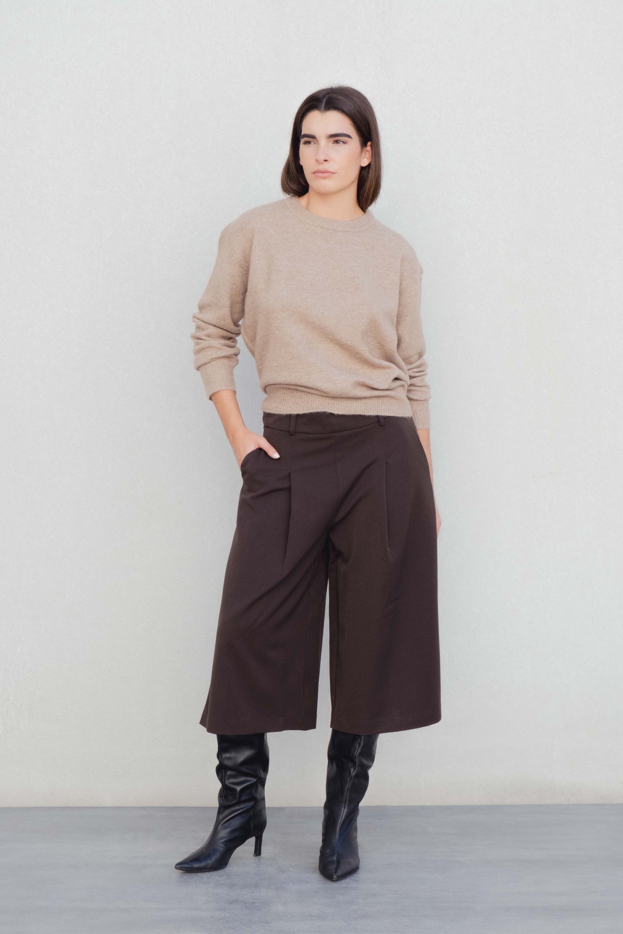 Modèle mettant en valeur le Bermuda long à pinces coupe droite marron coton stretch avec un pull beige, idéal pour un style casual-chic, représentant le bermuda large femme et bermuda femme long.