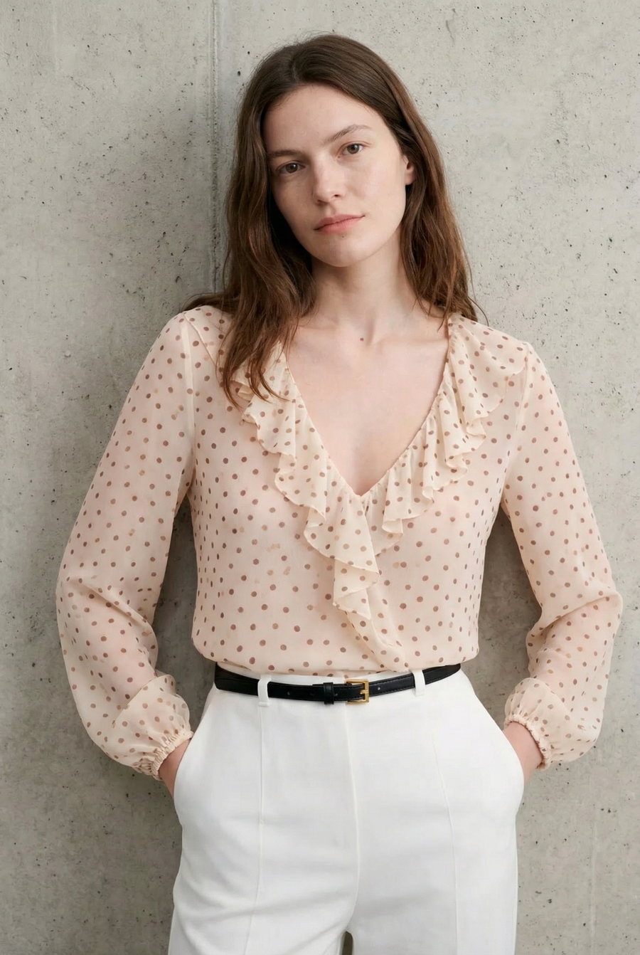 Blouse à volants pois écru devant mur