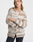 Une femme en tenue casual portant un cardigan court en maille beige et crème. Ce cardigan court femme en maille est parfait pour superposer.