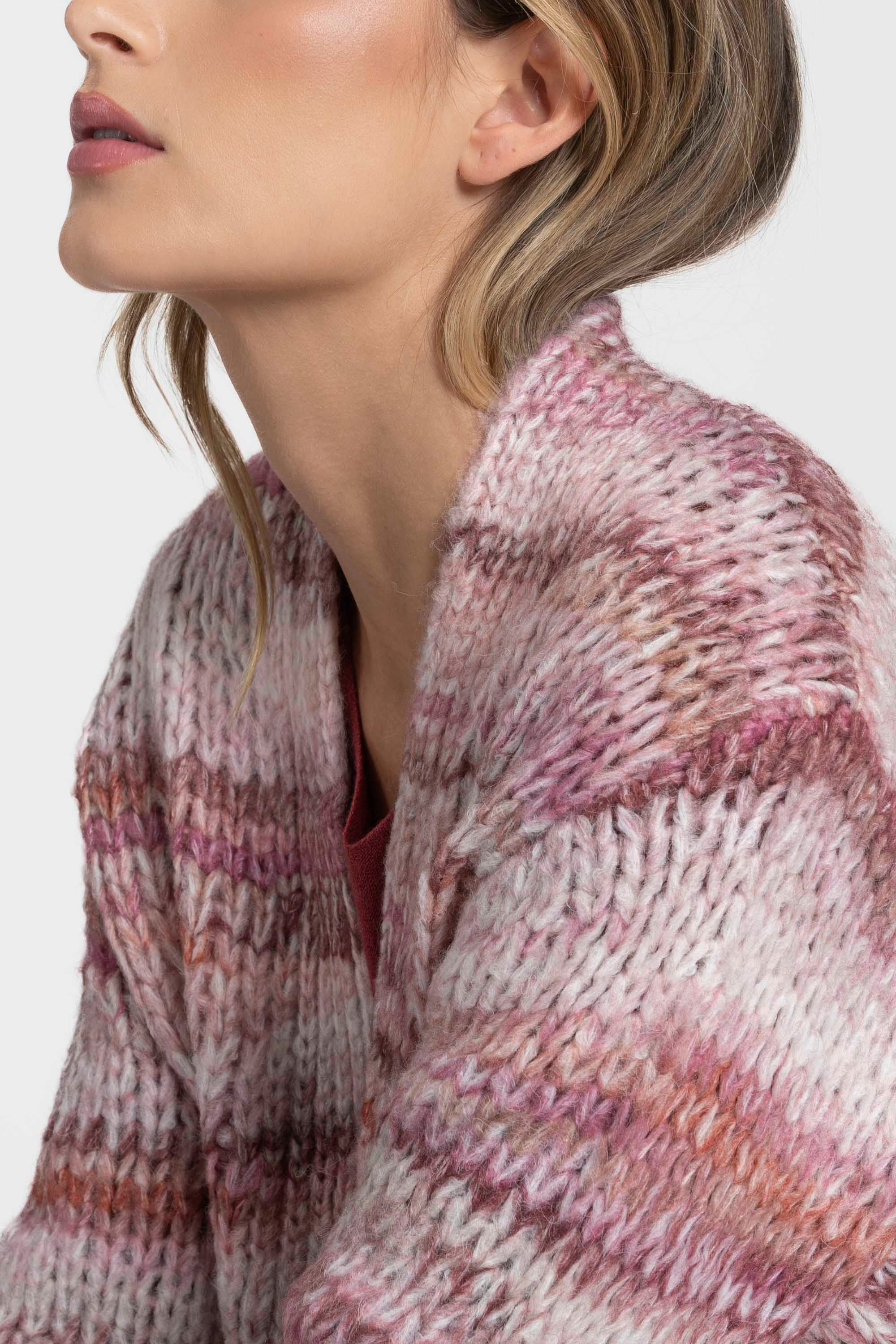 Profil d'une femme portant un cardigan court en maille avec des teintes roses, mettant en avant la texture douce. C'est un cardigan court femme en maille idéal pour la mi-saison.