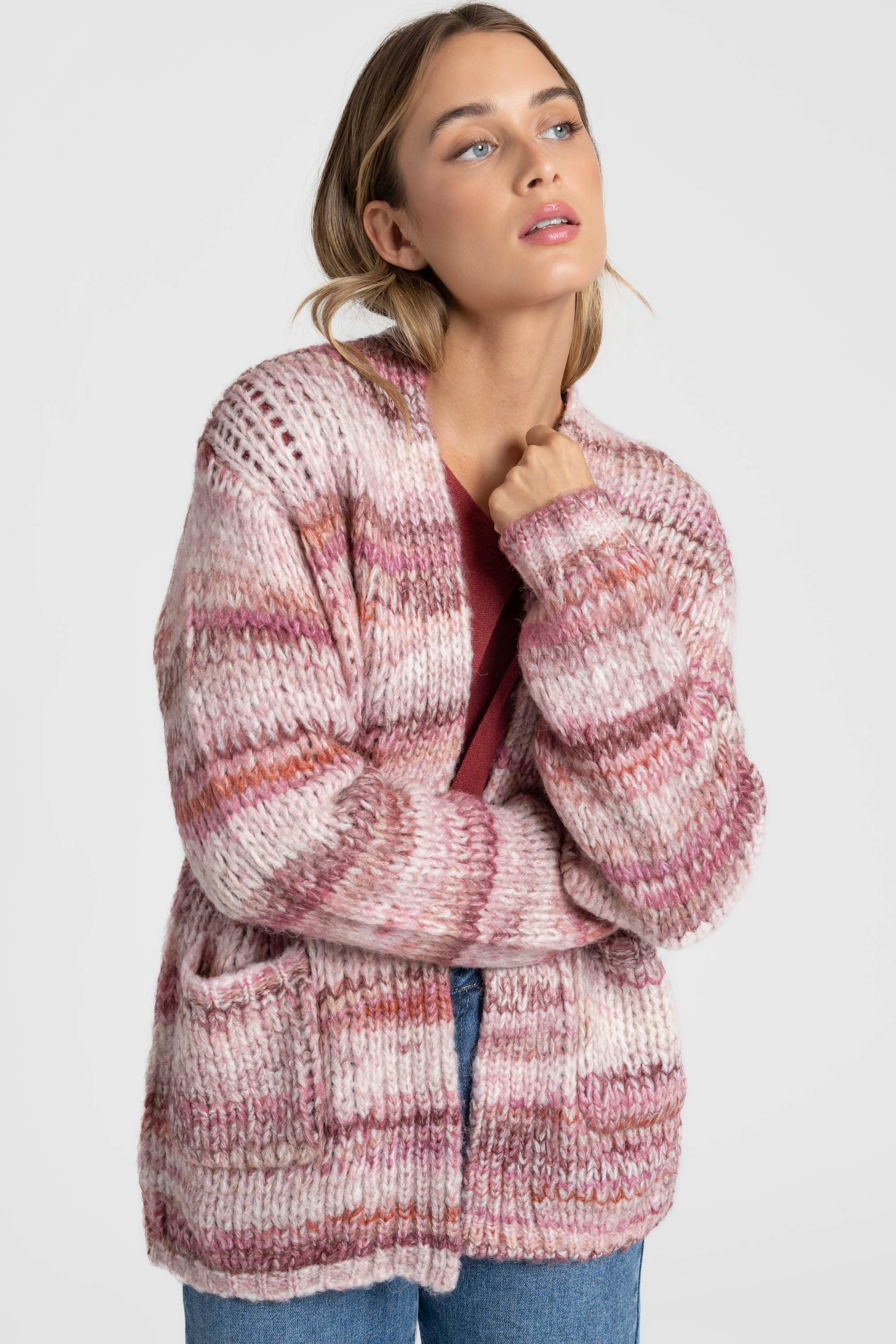 Femme regardant vers l'avant, vêtue d'un cardigan court en maille coloré, avec des poches. Ce cardigan court femme en maille est parfait pour un look décontracté.