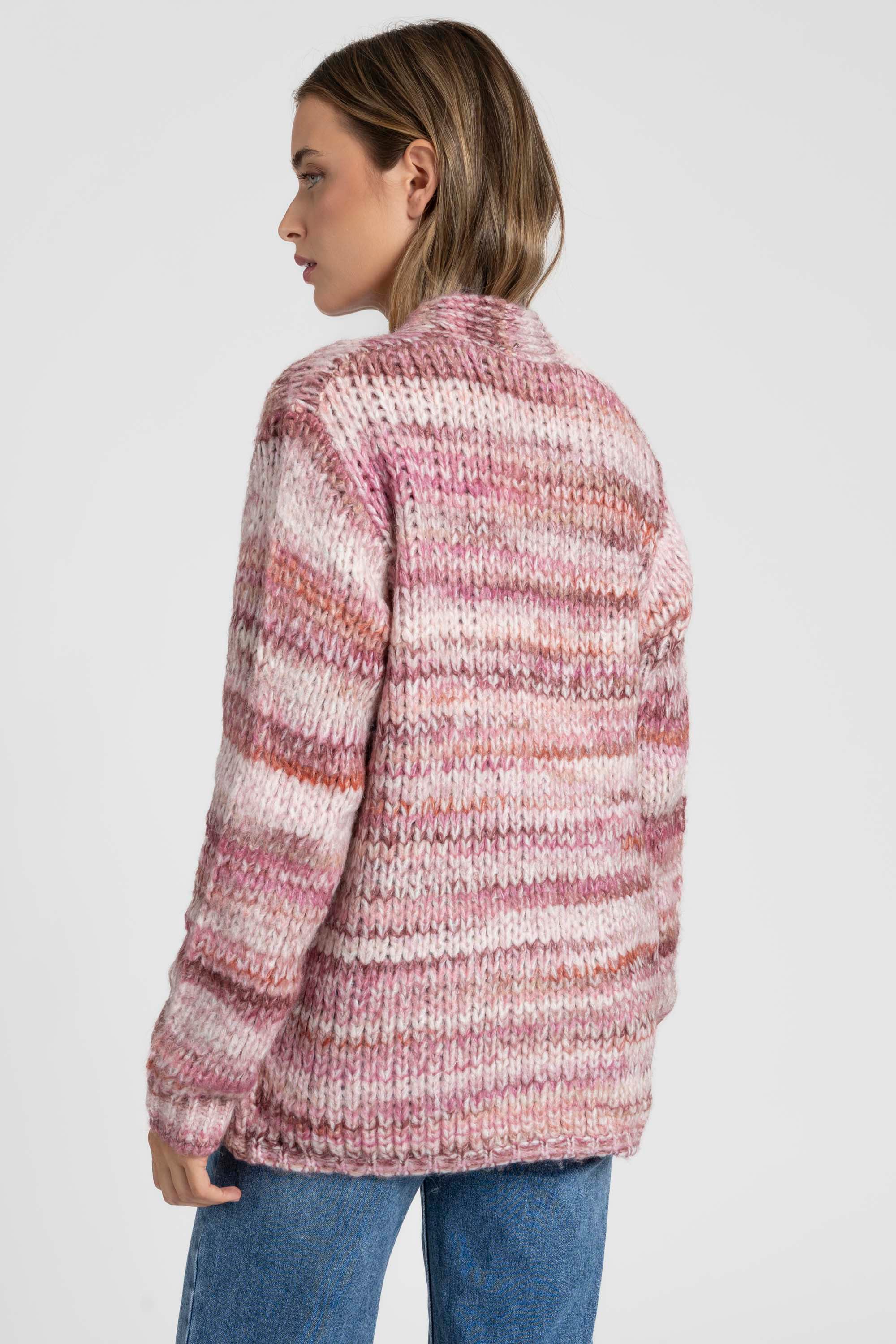 Vue arrière d'une femme portant un cardigan court en maille aux couleurs roses et beiges. Le cardigan court femme en maille ajoute une touche de chaleur et de style.