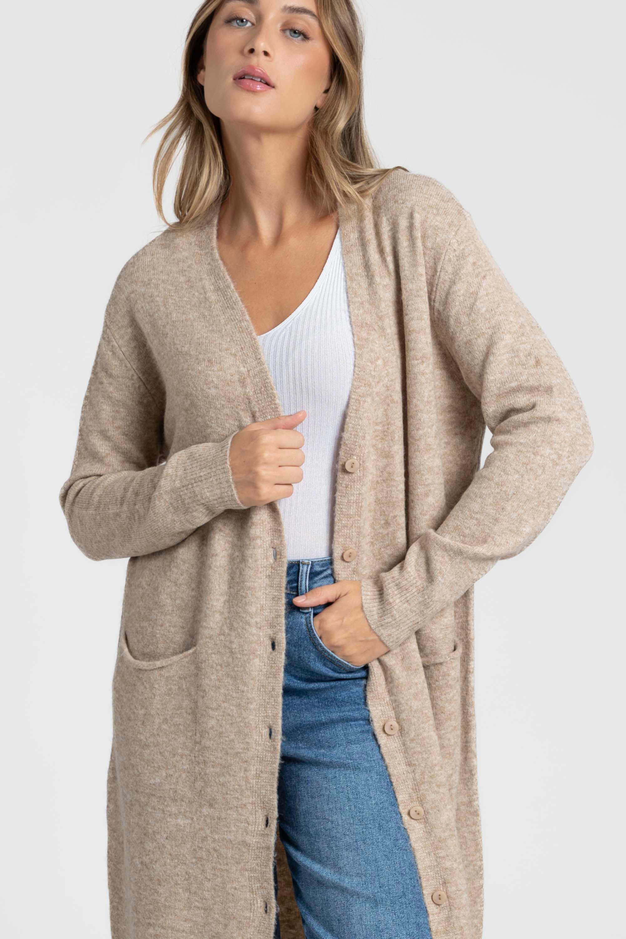 Femme de dos portant un cardigan long femme beige, en laine mélangée, avec une coupe confortable et relaxante.
