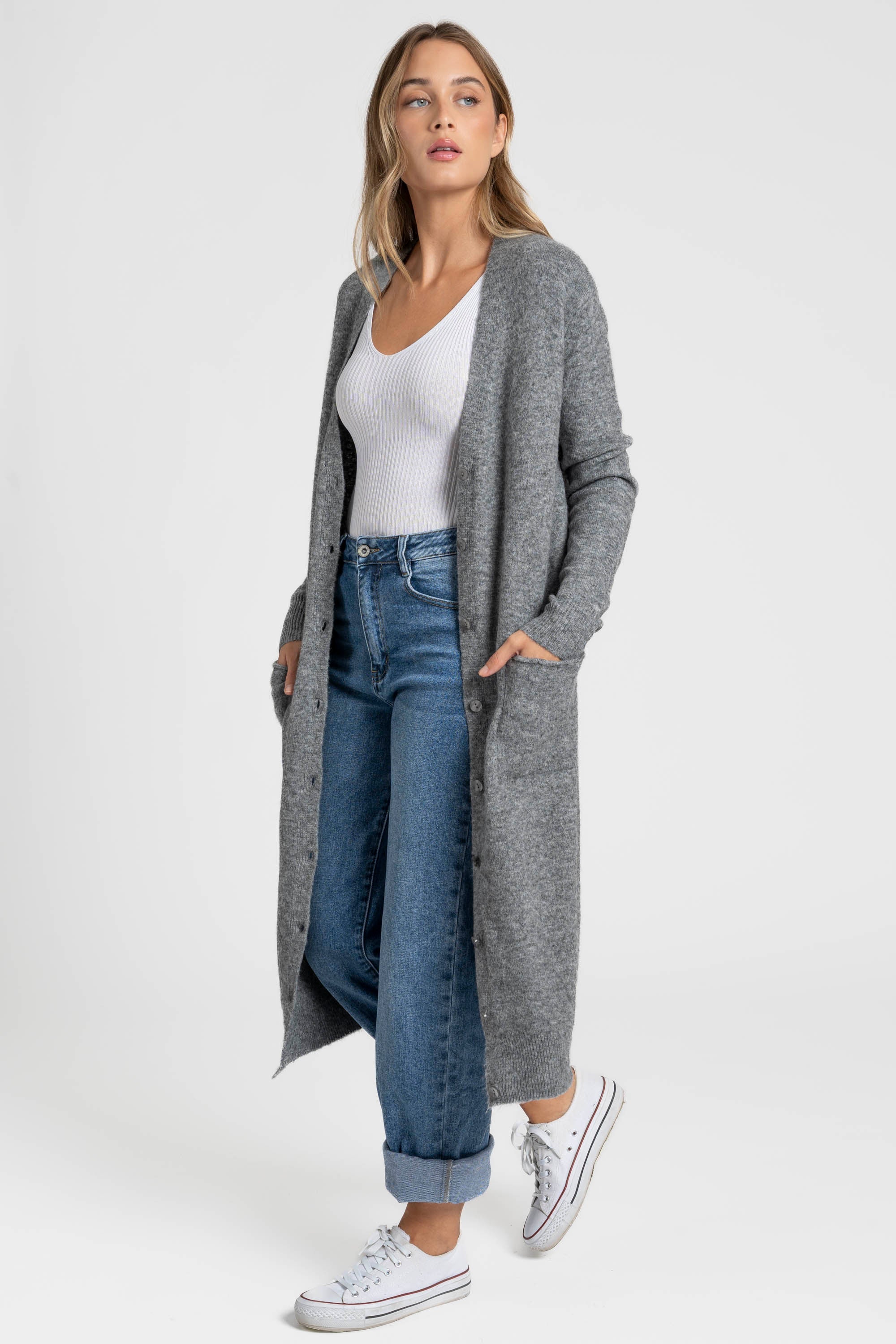 Femme avec un cardigan long femme gris, en laine mélangée, affichant une silhouette élégante avec des boutons modernes.