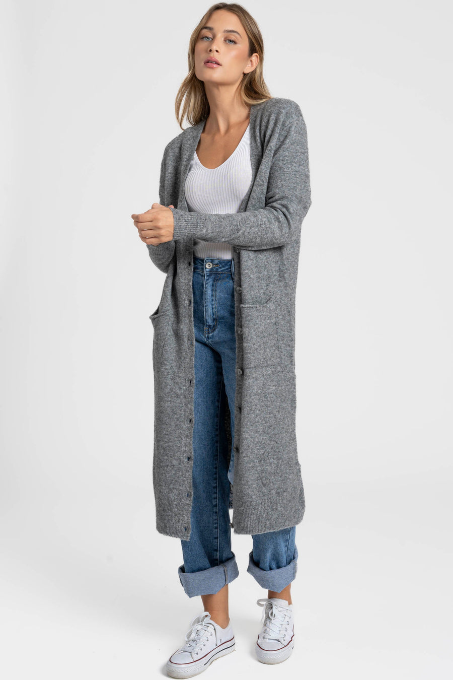 Modèle debout portant un cardigan long femme gris, en laine mélangée, avec une coupe droite, parfait pour un style casual.