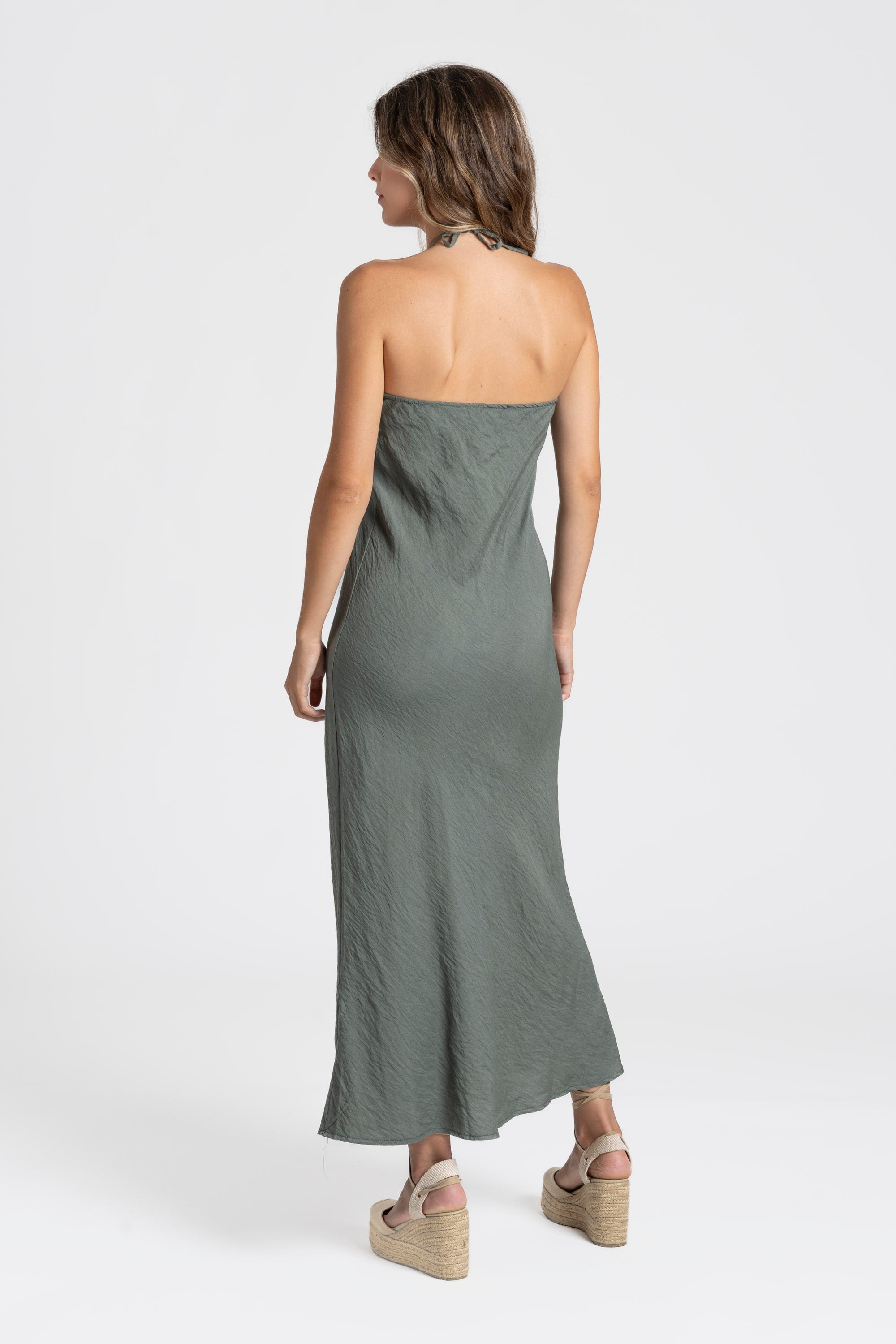 Vue arrière d'une robe midi halter fluide en viscose verte, mettant en avant sa conception adaptée pour les journées chaudes.
