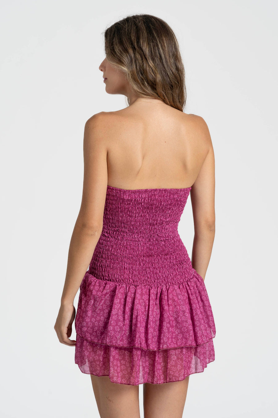Vue arrière de la robe courte étoilée en rose, accentuant la taille.