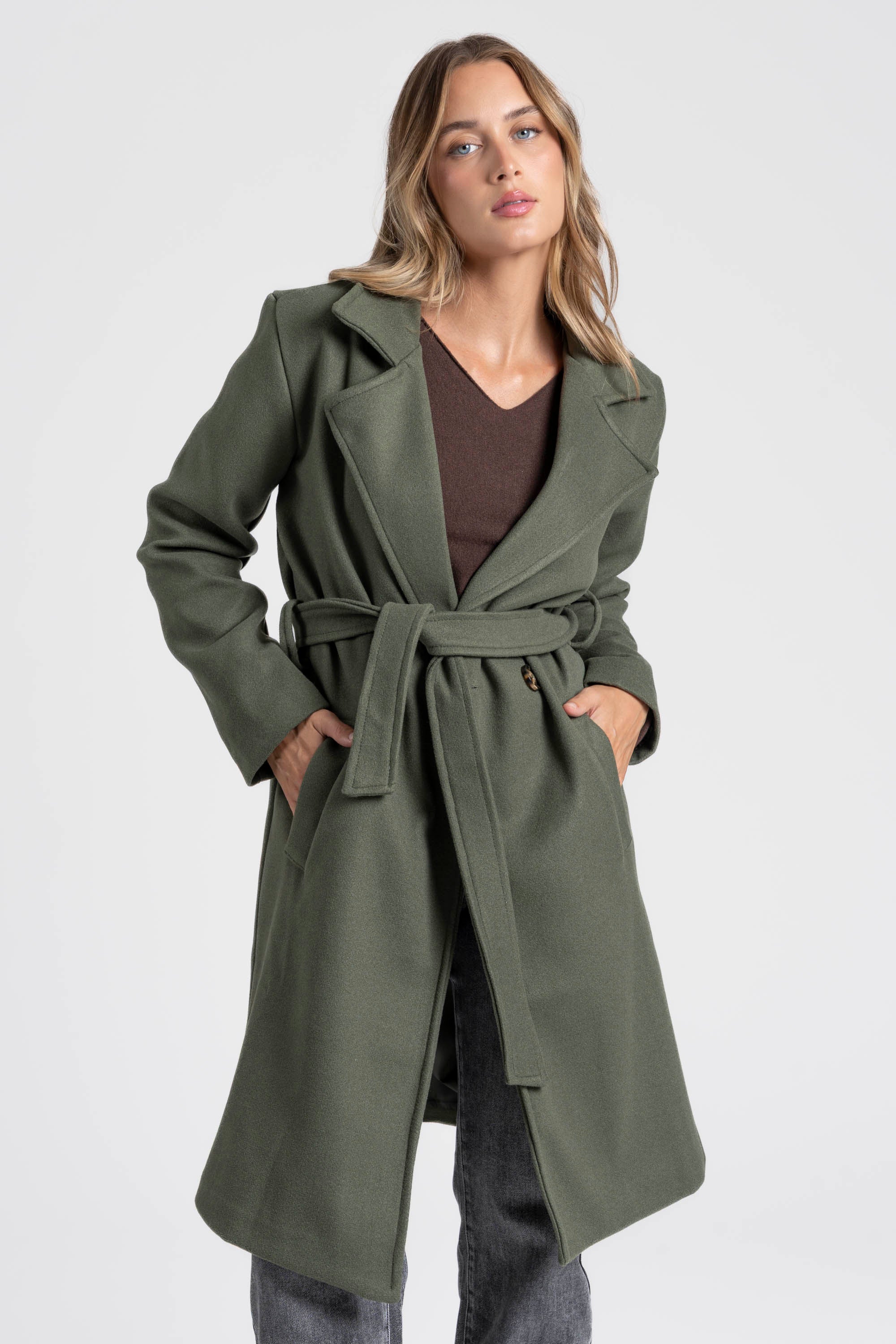 Manteau croisé femme en vert, porté avec une tenue décontractée, idéale pour les journées fraîches.