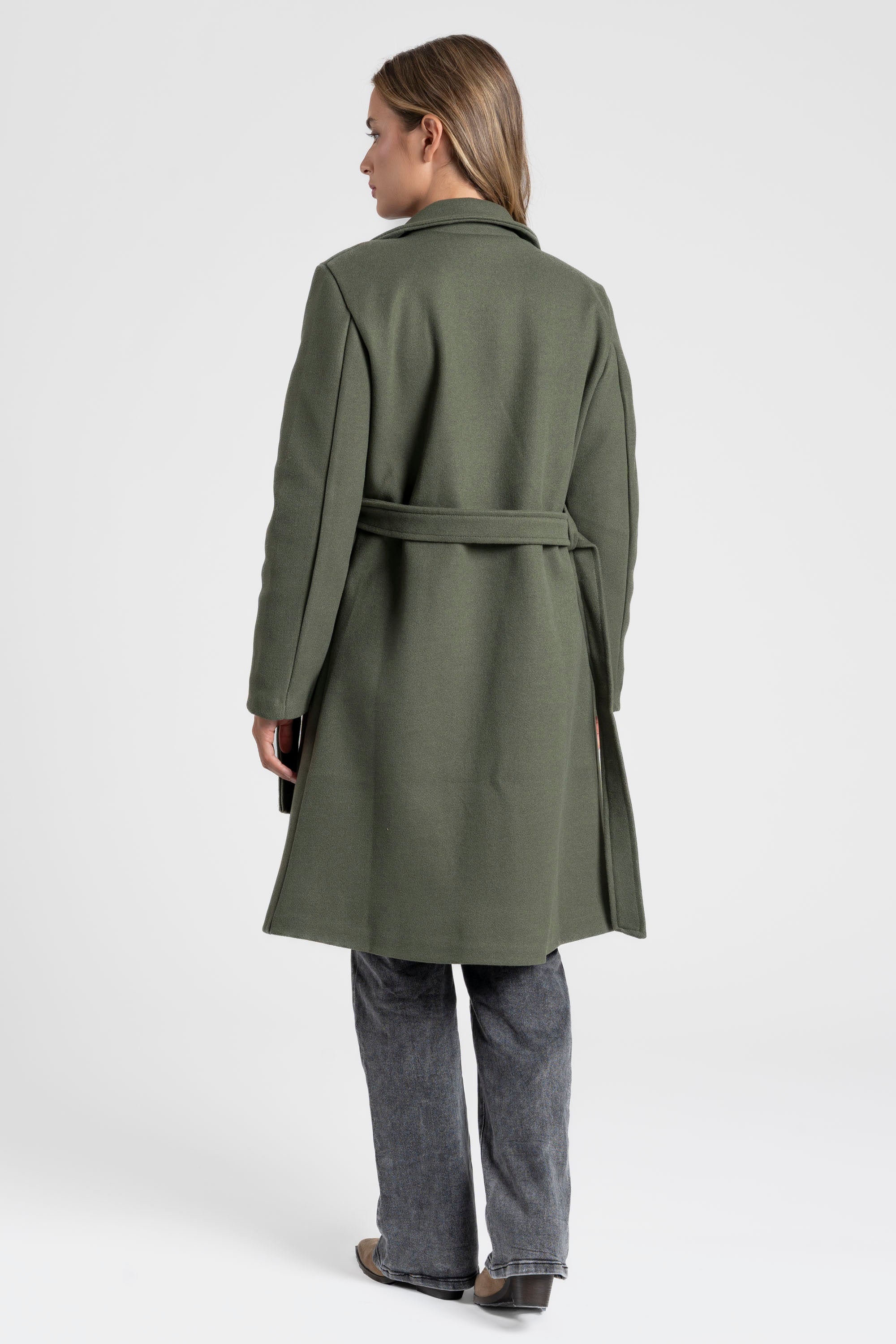 Démonstration du manteau croisé femme vert, montrant la coupe élégante au dos.