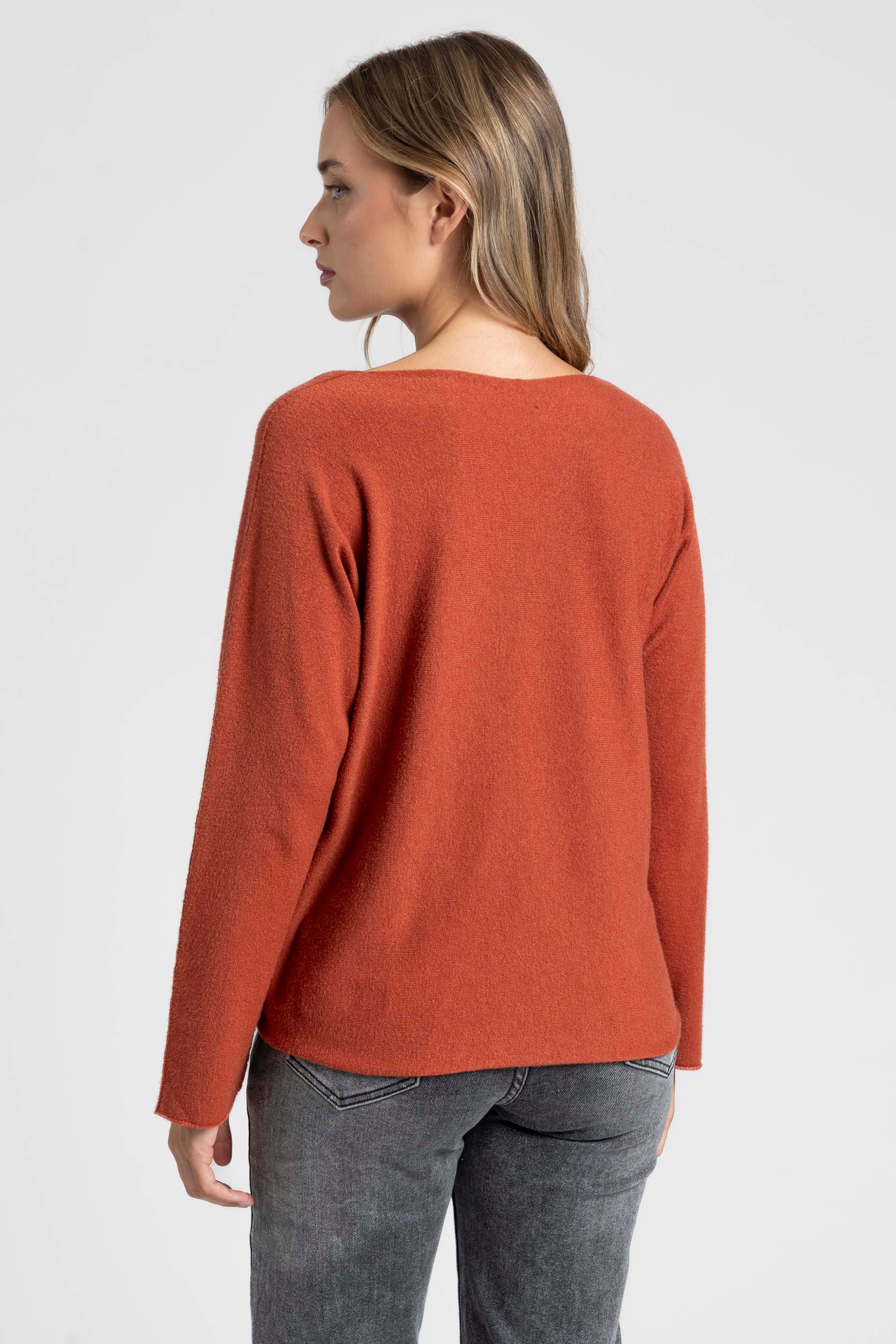 Pull fin col V femme couleur orange, présenté avec un haut gamme de styles, idéal pour le jour.