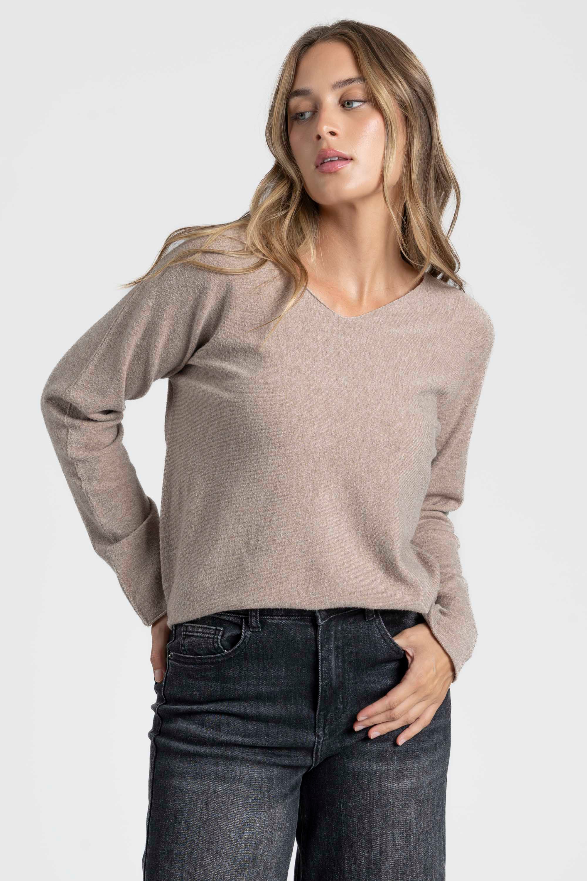 Pull col V femme en beige, mettant en avant sa fonctionnalité et son style polyvalent.
