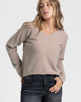Pull col V femme en beige, mettant en avant sa fonctionnalité et son style polyvalent.
