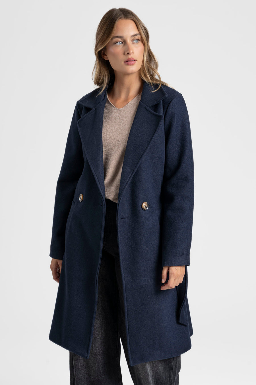 Manteau croisé femme bleu marine, mettant en avant la qualité du tissu et du design.