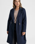 Manteau croisé femme bleu marine, mettant en avant la qualité du tissu et du design.