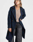 Manteau croisé femme bleu marine, offrant une touche de couleur pour un look printanier.