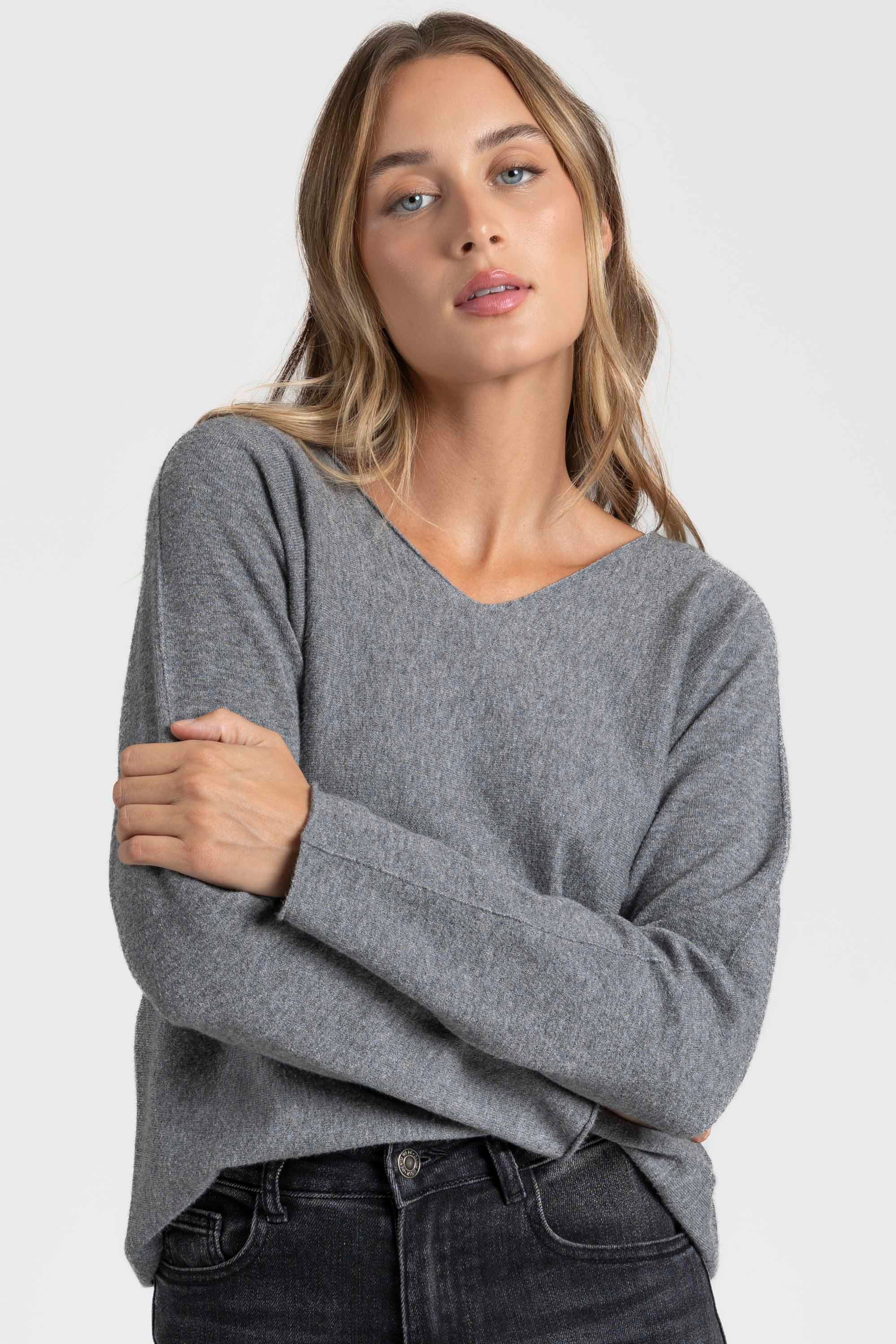 Pull col V femme en gris, associant confort et tendance pour le dressing moderne.