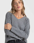 Pull col V femme en gris, associant confort et tendance pour le dressing moderne.