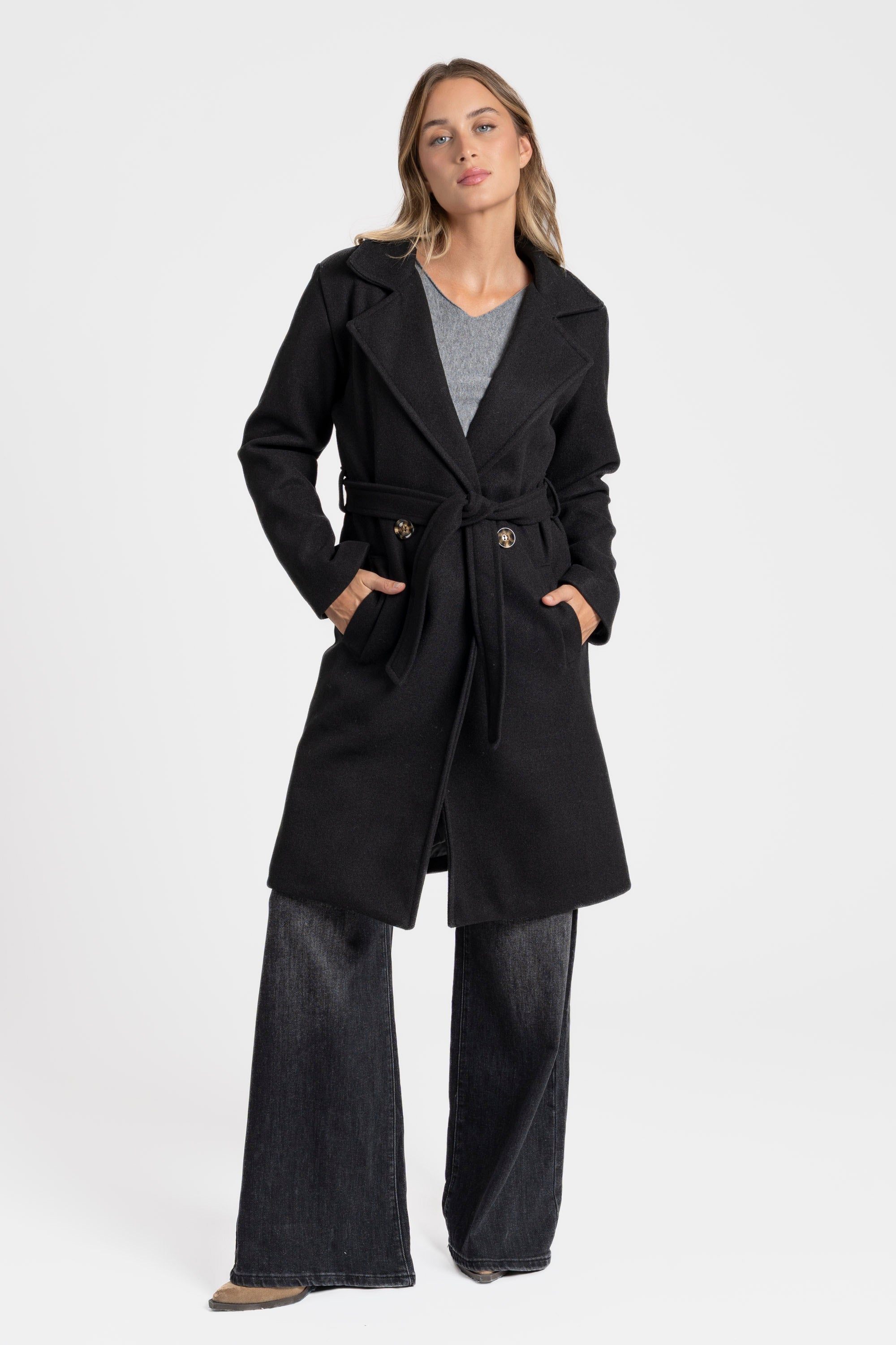 Manteau croisé femme noir, associé avec une tenue chic, idéal pour les occasions formelles.
