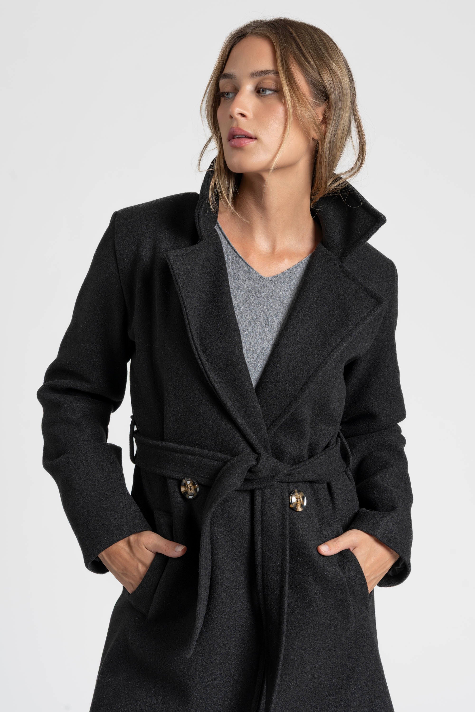 Manteau croisé femme noir avec un col structuré, parfait pour les looks d'hiver.