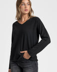 Pull col V femme couleur noir, associé à un jean, ajoutant une touche vibrante à la garde-robe.