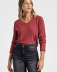 Pull col V femme couleur bordeaux, offrant une alternative trendy pour les looks quotidiens.