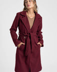 Manteau croisé femme bordeaux, offrant une silhouette féminine et chic.