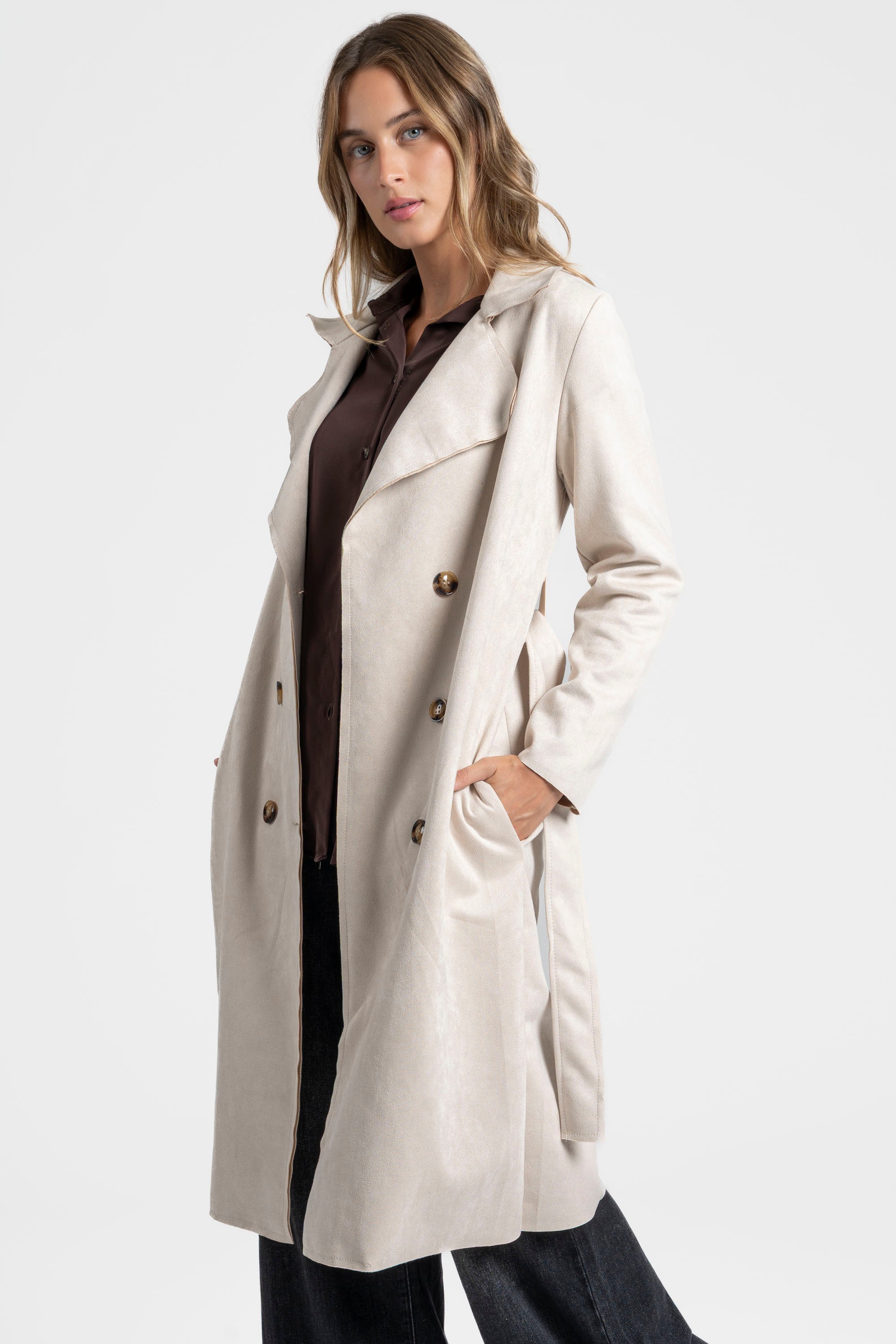 Trench femme ceinture beige de face, mettant en avant sa finition soignée et ses poches.