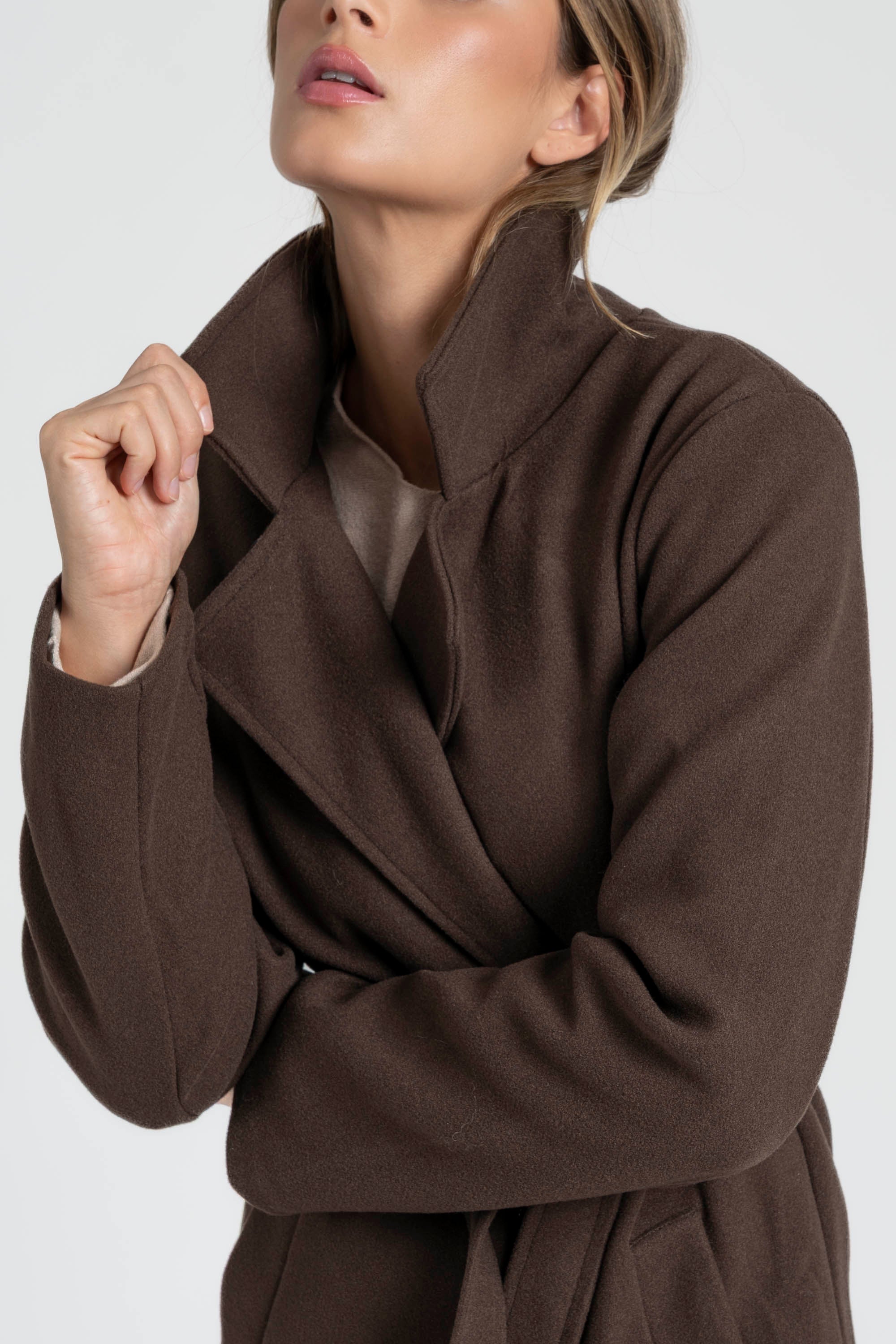 Premier plan sur le manteau croisé femme marron, soulignant la finition soignée et le tissu chaleureux.