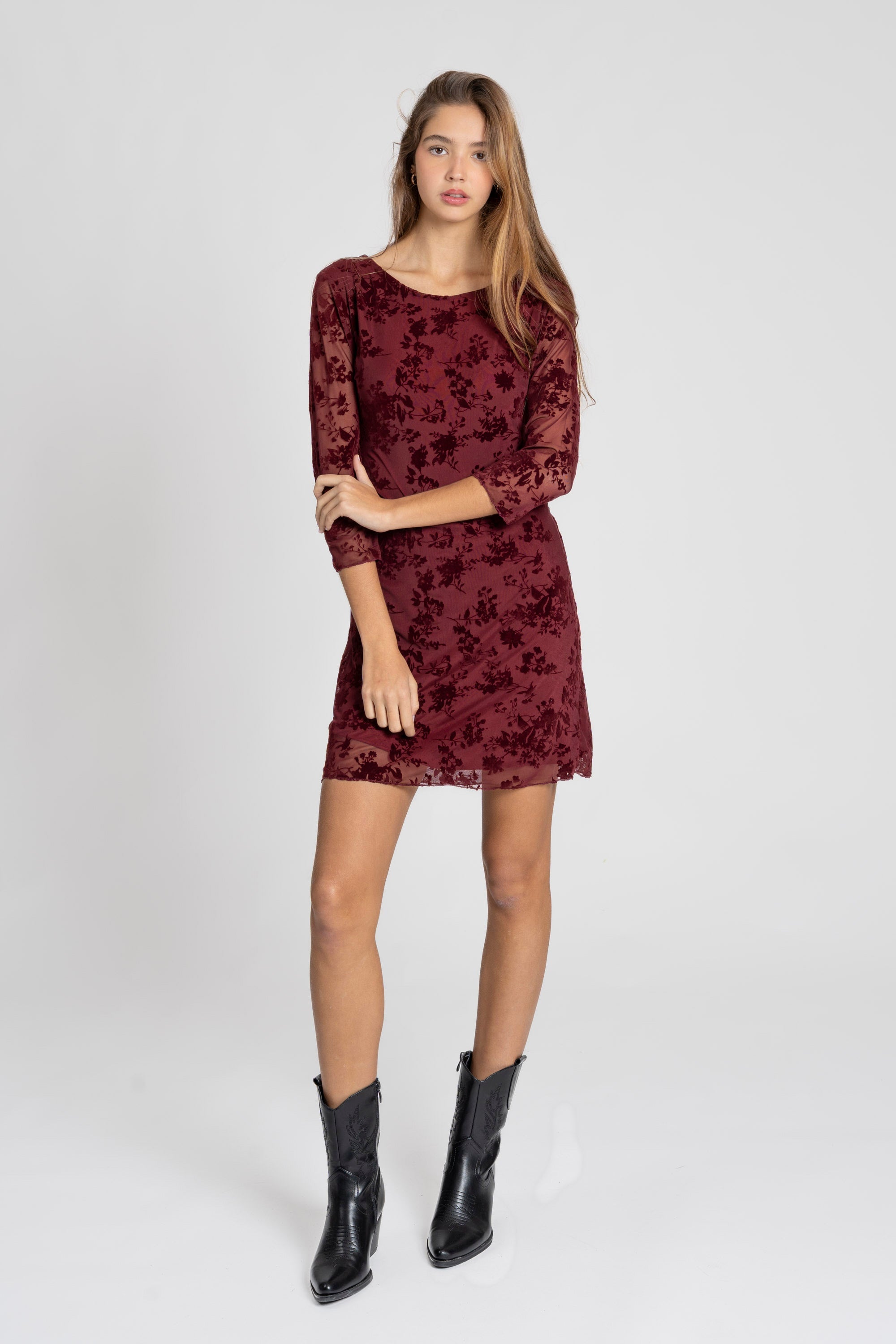Femme portant une robe courte dentelle chic manches 3/4 bordeaux en maillot stretch, mettant en valeur un design élégant. Parfaite pour une soirée habillée, robe courte dentelle.